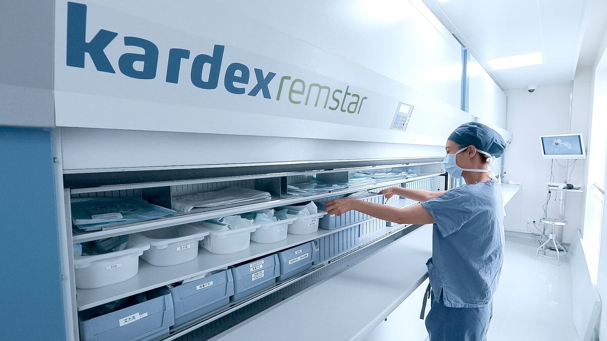 Hospital staff retrieving surgical kits from a Kardex vertical carousel, demonstrating sterile supply storage and automated access in healthcare
