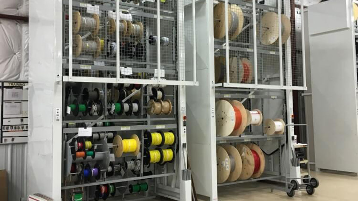 Industrial carousel rack system for storing and accessing a variety of colored cable and hose wire spools vertically