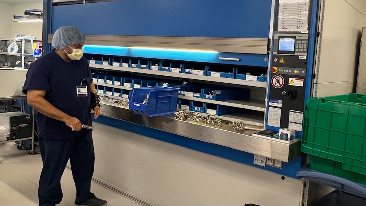 Technician retrieving sterile supplies at an ergonomic access opening