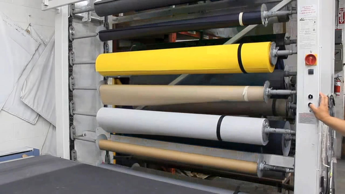 Automated vertical carousel storing colorful fabric rolls in a space-saving textile storage solution
