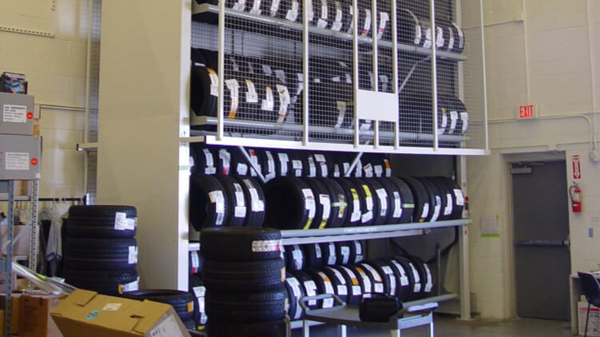 Motorized tire carousel rack with vertical storage compartments for efficient space-saving tire inventory management