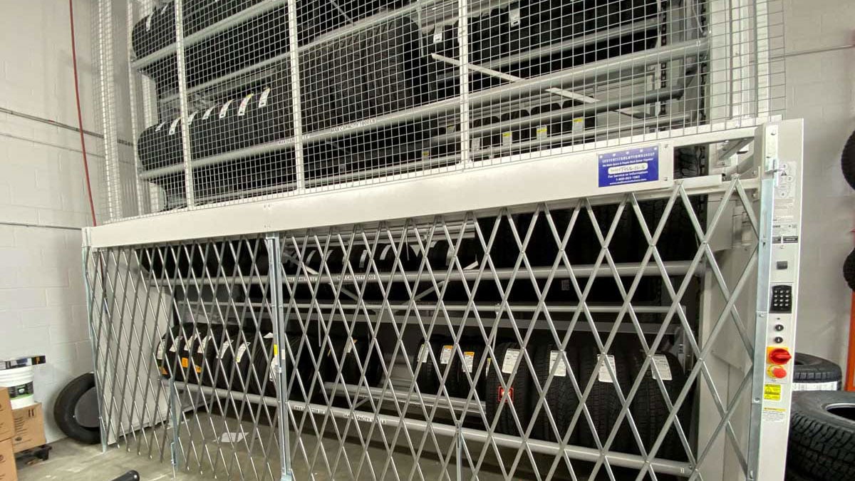 Vertical tire carousel with safety gate for organized tire storage in service bays