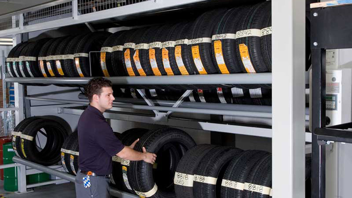 Technician accessing tires from a vertical carousel designed to maximize storage and streamline retrieval