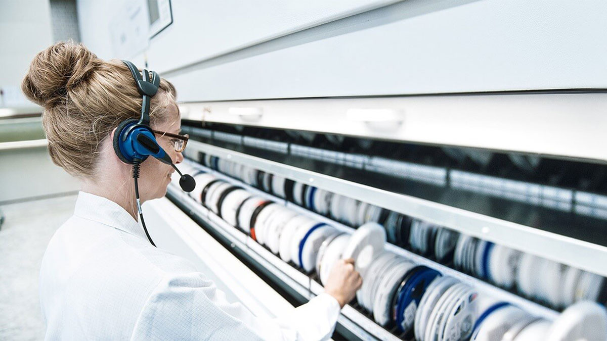 Technician retrieving components from an automated vertical carousel storage system using picking technology in a cleanroom setting