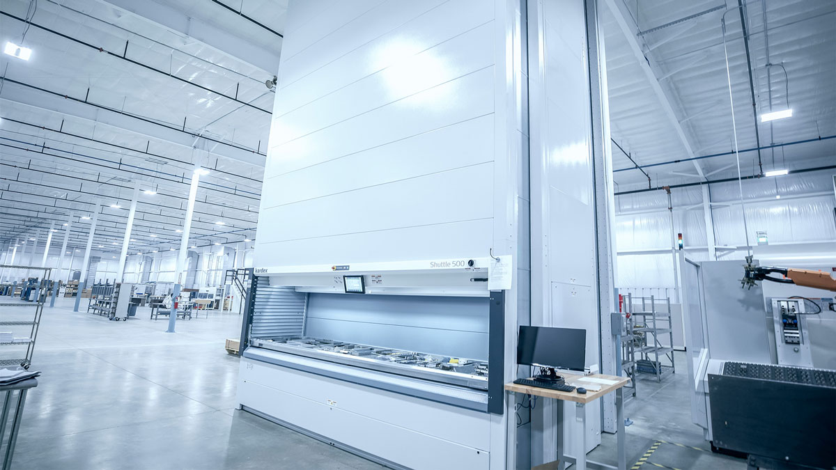Space-saving vertical lift module used for organizing packages and parts efficiently in an industrial warehouse environment