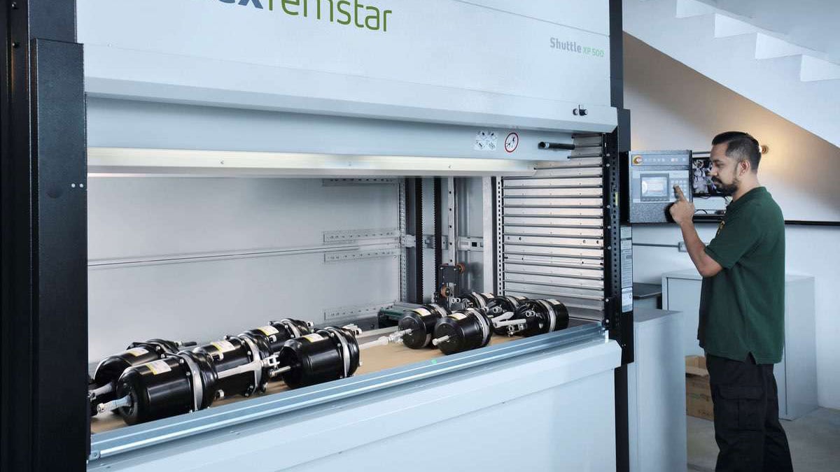 Technician operating Kardex Remstar VLM to retrieve heavy mechanical parts
