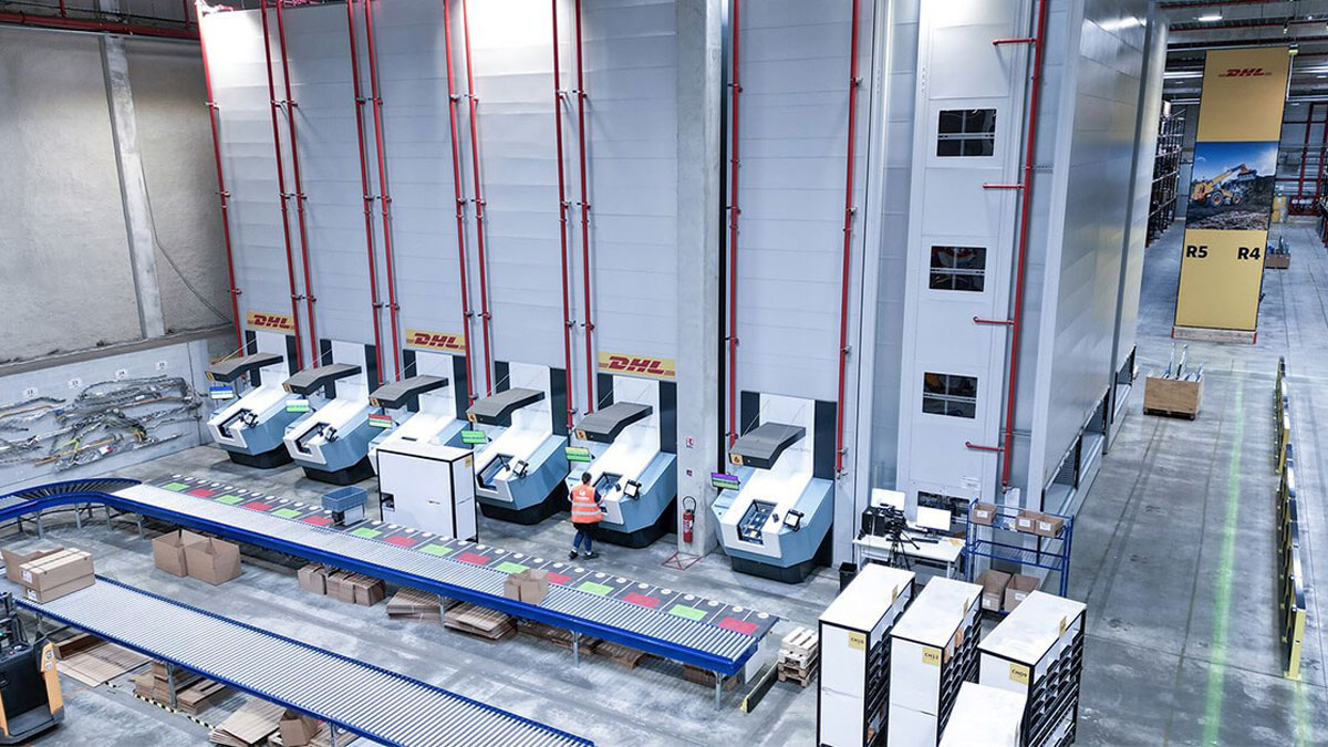 DHL logistics center with multiple vertical lift modules integrated into a conveyor belt system, enabling high-volume automated shuttle-based storage and retrieval