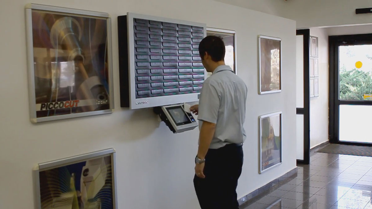 staff using touchscreen on lobby wall mounted electronic key access panel for secure key retrieval