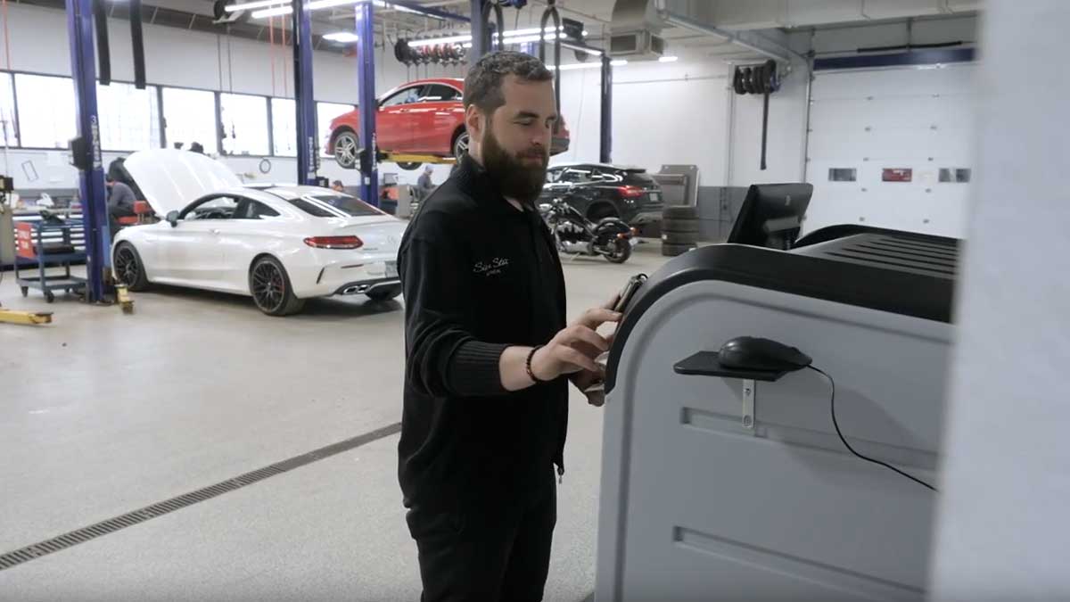 Service staff scanning key tag at electronic key cabinet touchscreen for secure audit tracking