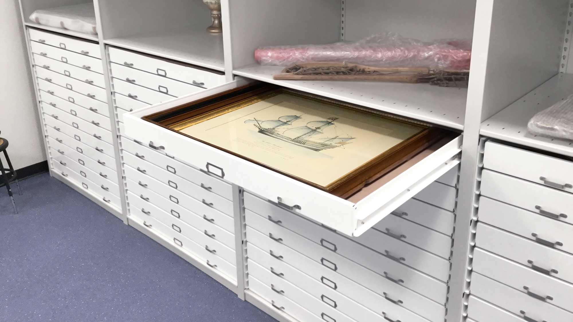 Flat file storage cabinet with extendable trays below open shelving
