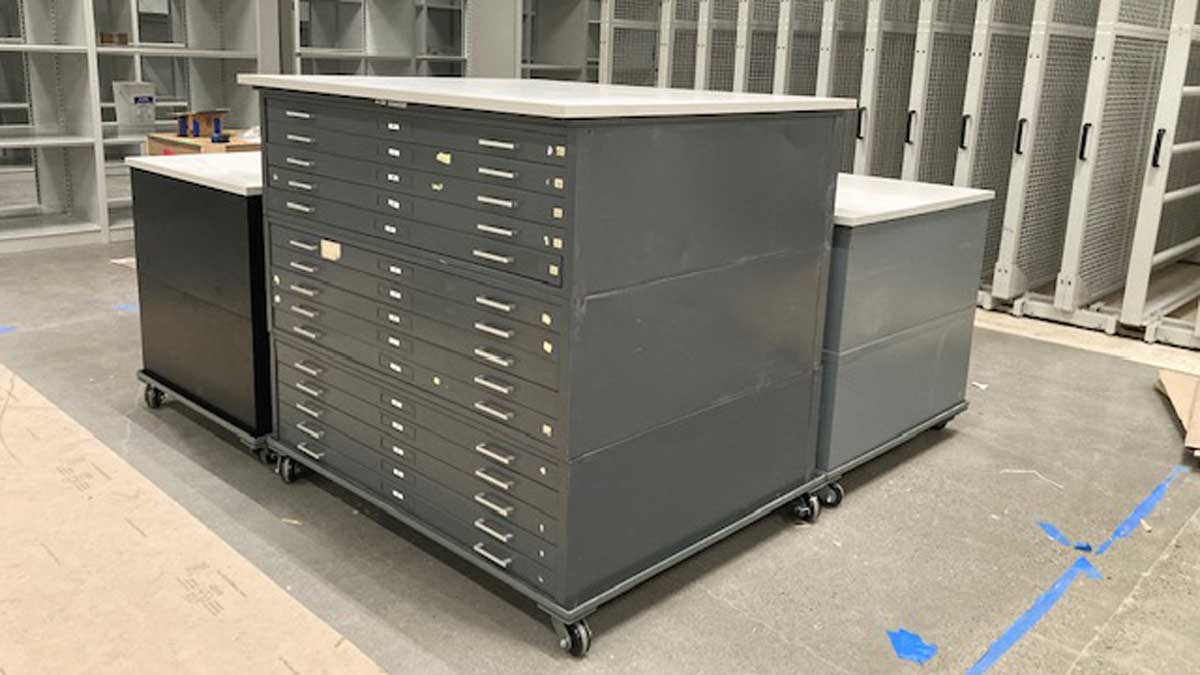 Archival flat file cabinets on casters in an art storage aisle