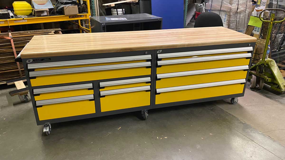 L-shaped configuration of grey modular drawer cabinets with a worktop in a workshop.