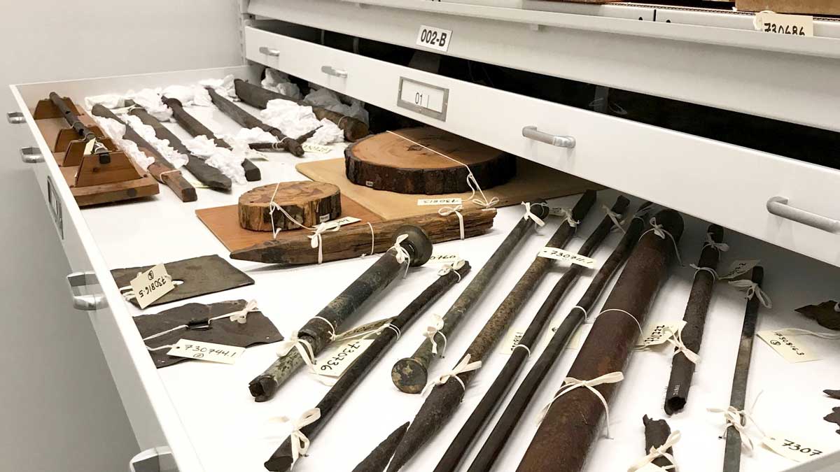 artifacts stored in extra-wide trays placed on widespan shelving for organized museum collections