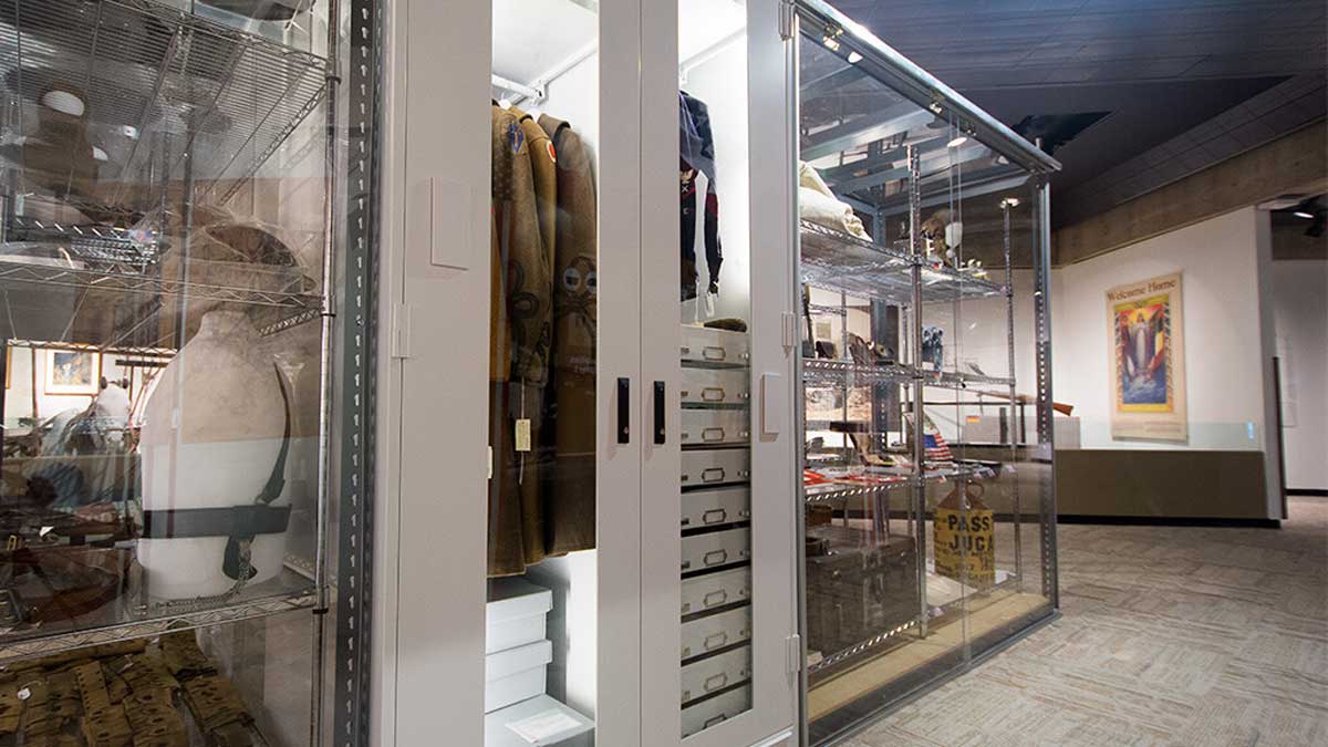 A museum cabinet with LED lighting showcasing Viking artifacts and textiles on adjustable shelves