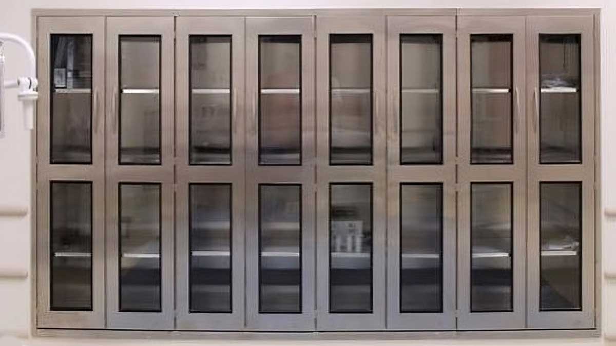 stainless steel wall cabinets with glass doors and multiple drawers providing secure organized storage for medical instruments and supplies