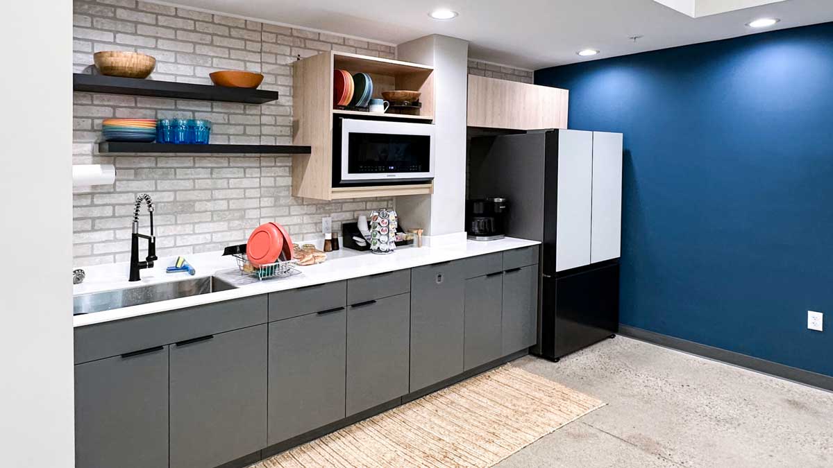 grey cabinetry kitchenette with toaster oven refrigerator and sink