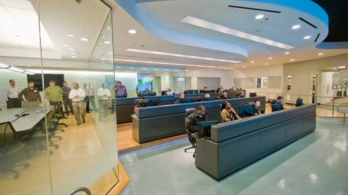 Training command room with organized desks and multiple monitoring screens