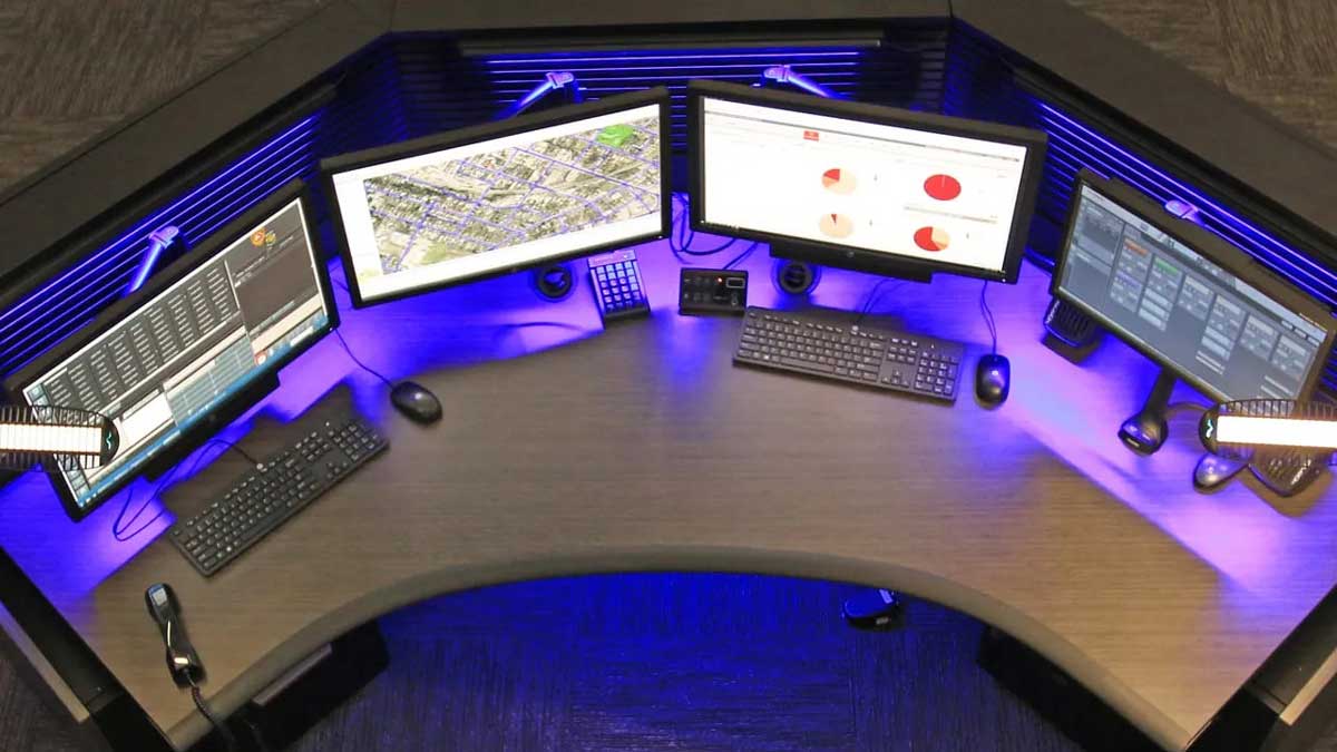 Control room consoles featuring blue accent lighting and multiple monitoring screens for operators