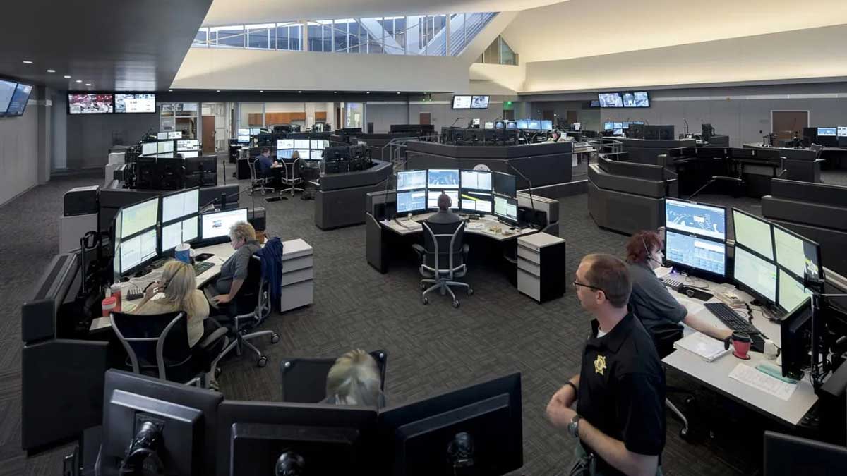 Public safety 911 dispatch center featuring modern consoles with multiple screens and ergonomic design for streamlined emergency communication.