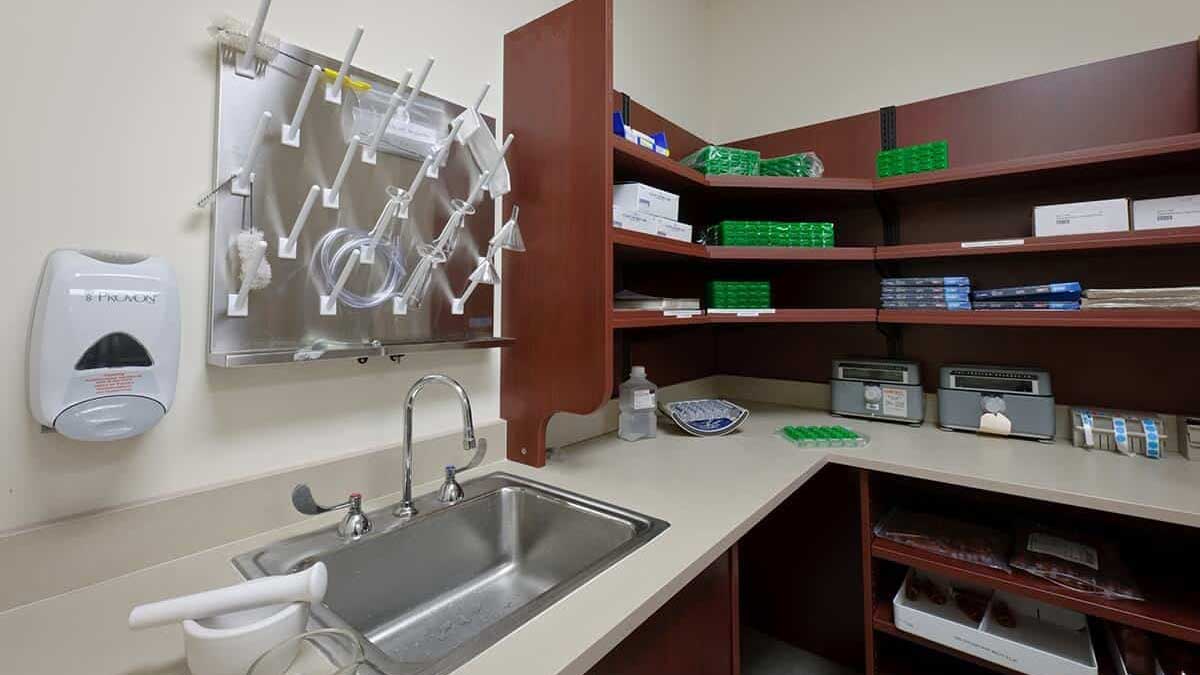 Lab workstations and cabinets with electrical outlets and sink, offering functional workspace for lab activities