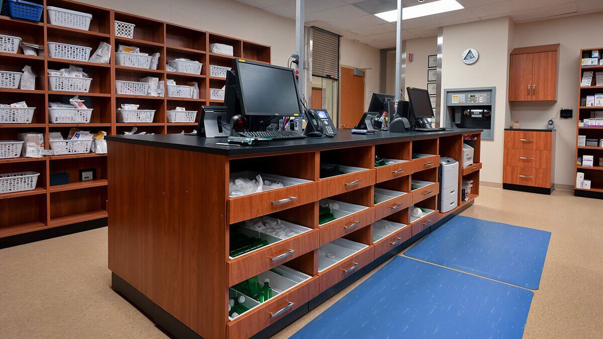Modular casework with open drawers and shelves at pharmacy workstation for medication organization