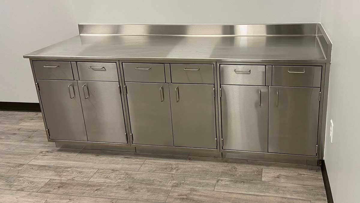 stainless steel base cabinets with drawers, countertop, and backsplash for laboratory or workspace storage