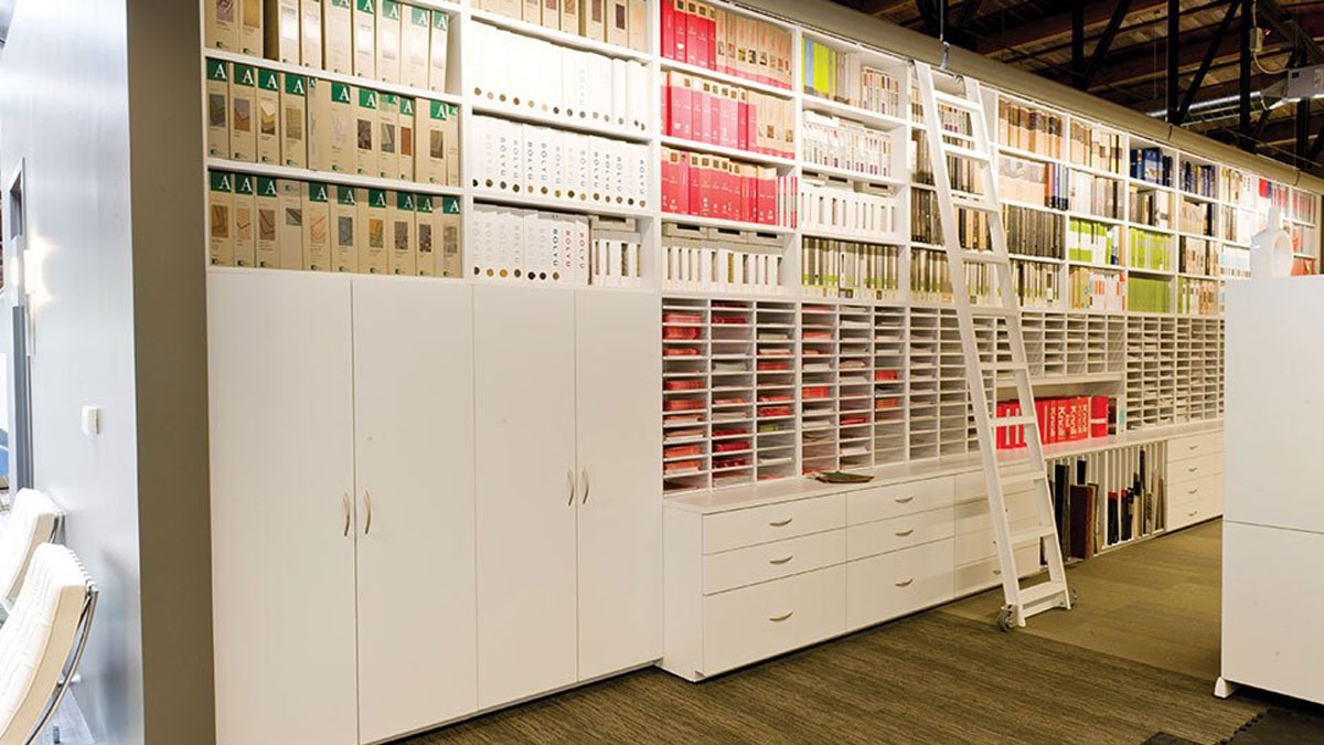 Full-height modular display wall casework with integrated file storage and rolling ladder access