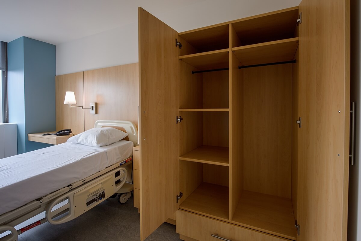 Modular wardrobe cabinet for patient room, featuring built-in shelves, hanging space, and integrated storage