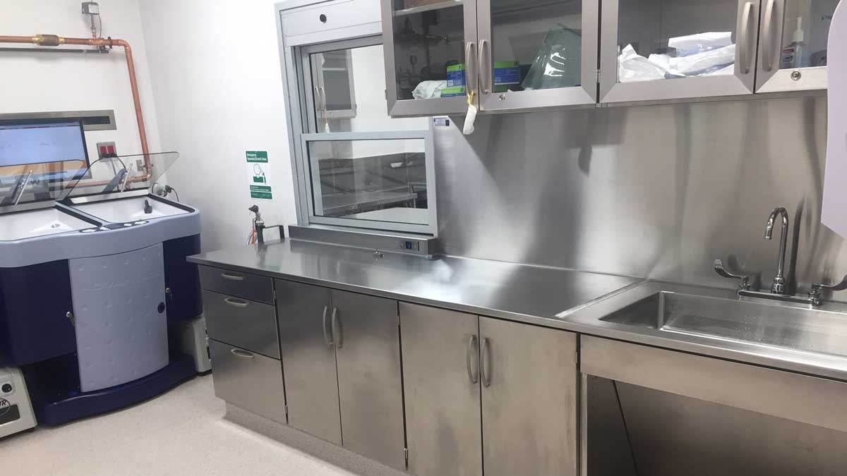 stainless steel workstation with integrated sink and upper cabinets with glass doors for sterile environment