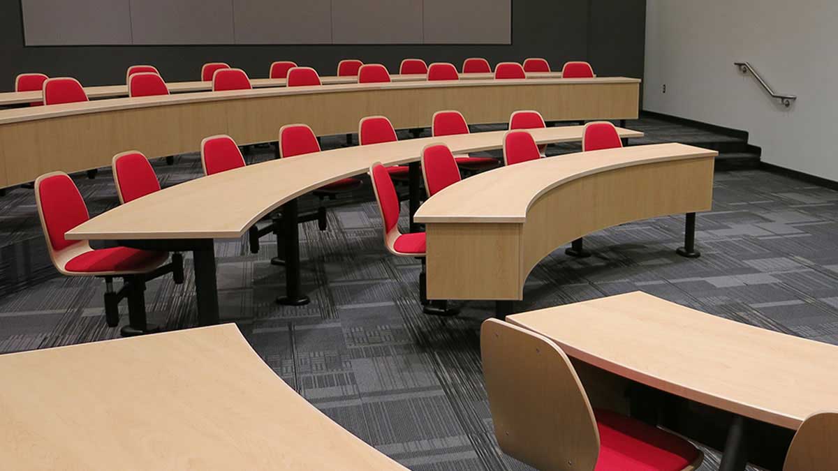 Auditorium seating with swing-away desks and comfortable padded chairs
