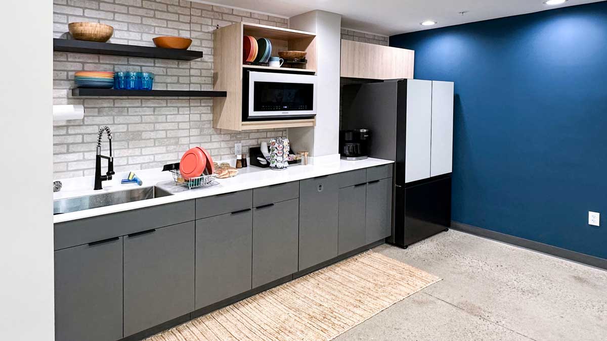 breakroom kitchenette with open shelving refrigerator and microwave for office lunch prep