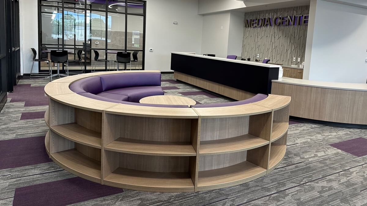High school library modern study area with mobile tables, chairs, and open shelf units for group learning