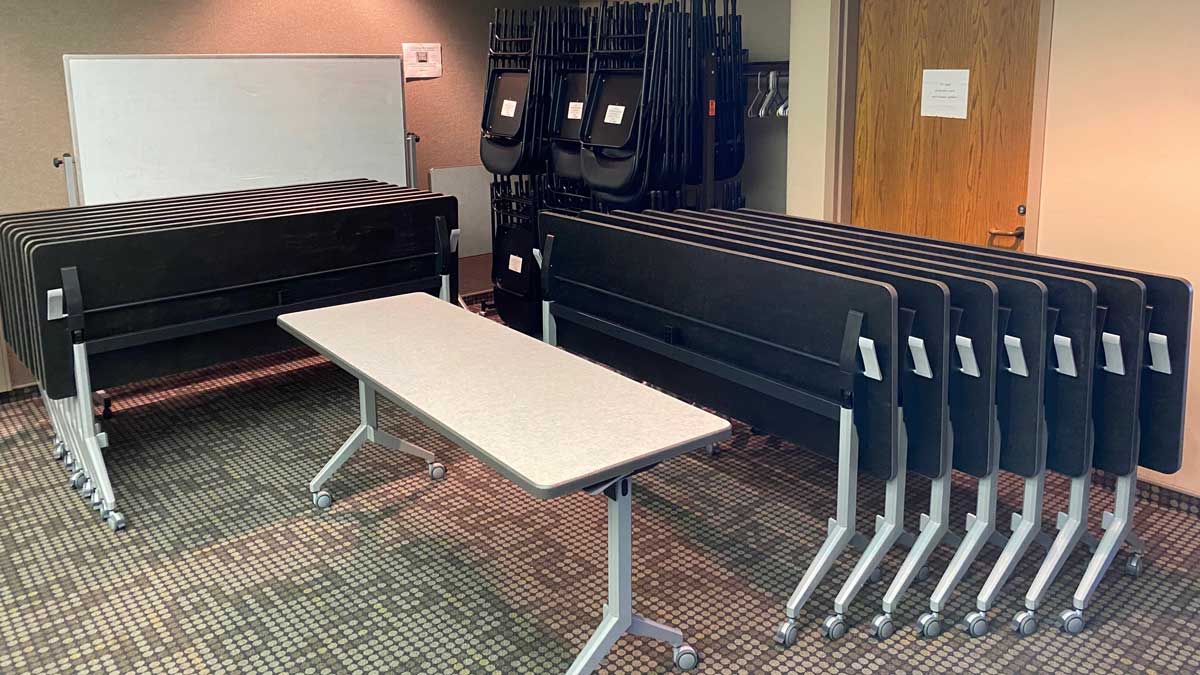 set of nesting training tables with flip-top surfaces stored on casters for compact storage in meeting rooms