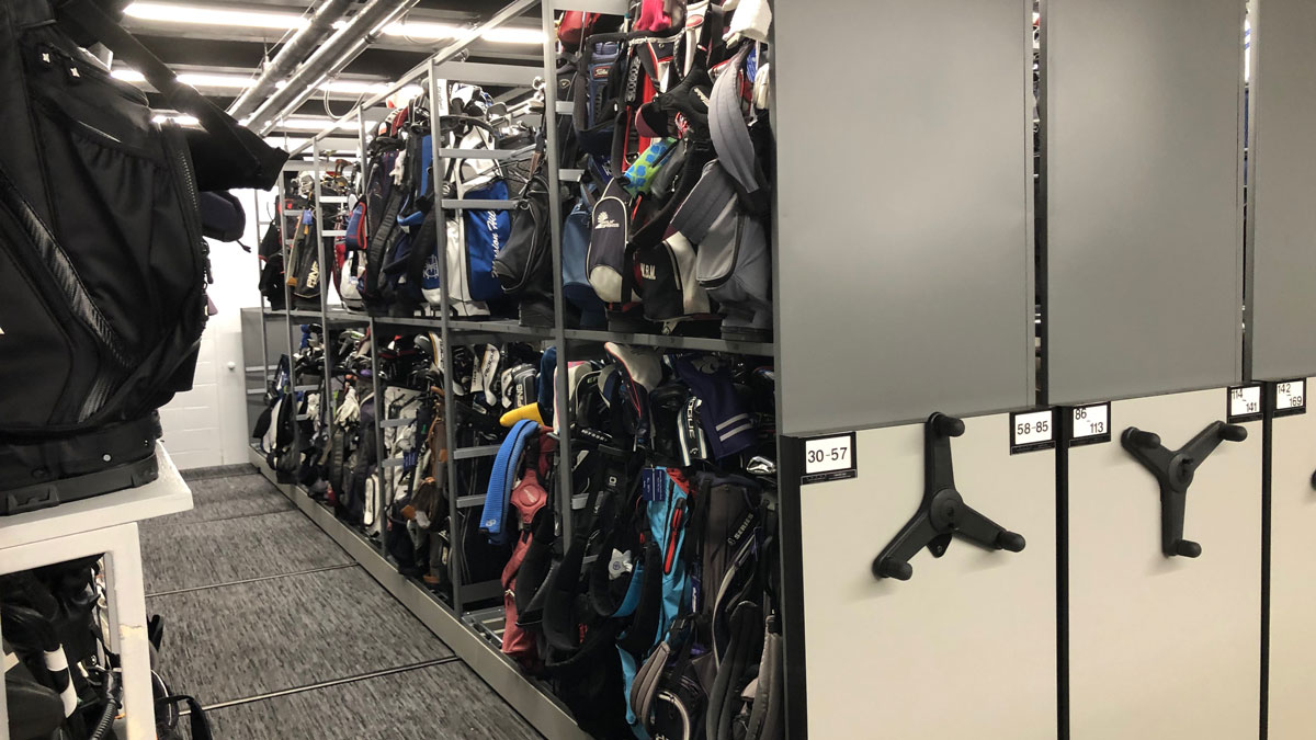commercial golf bag storage rack with rolling shelves holding multiple golf bags in compact space
