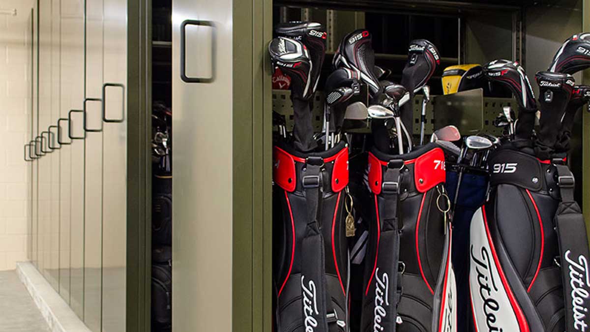 high-density mobile shelving with vertical compartments to store golf bags in resort locker rooms