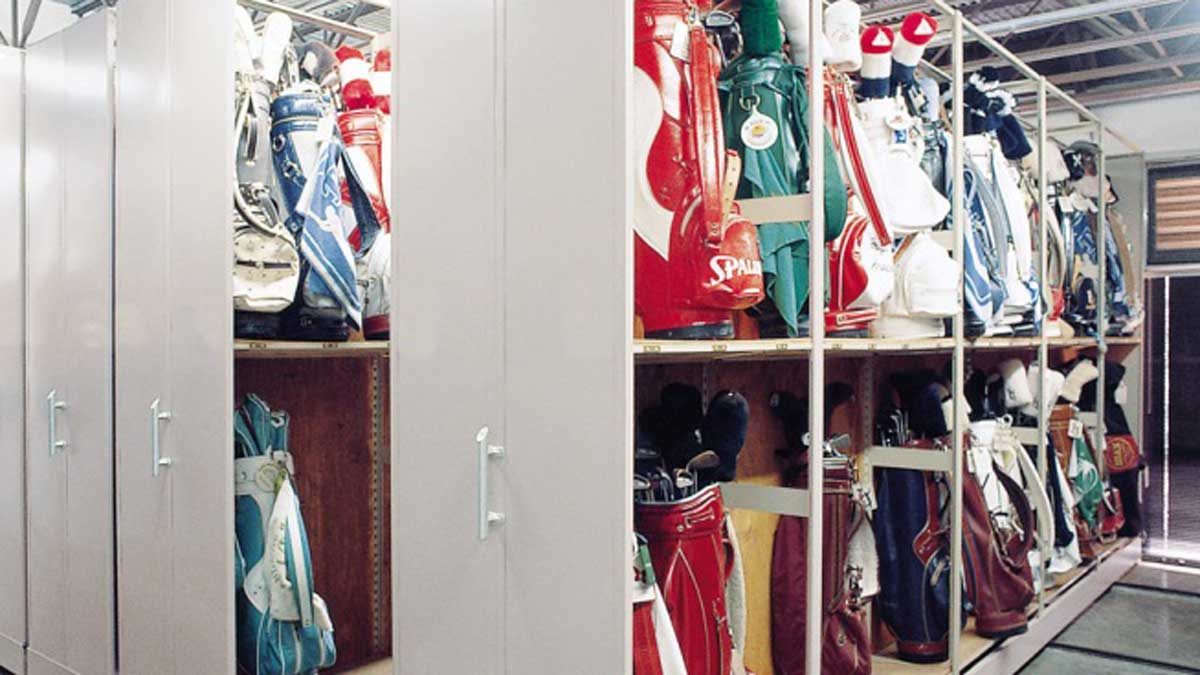 Manual mobile shelving with golf bag racks in a school team equipment room