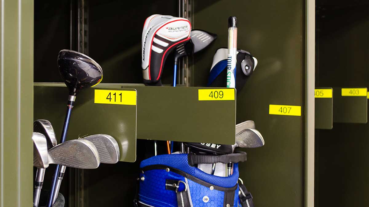 Numbered compartment shelving used as golf bag racks at a busy facility
