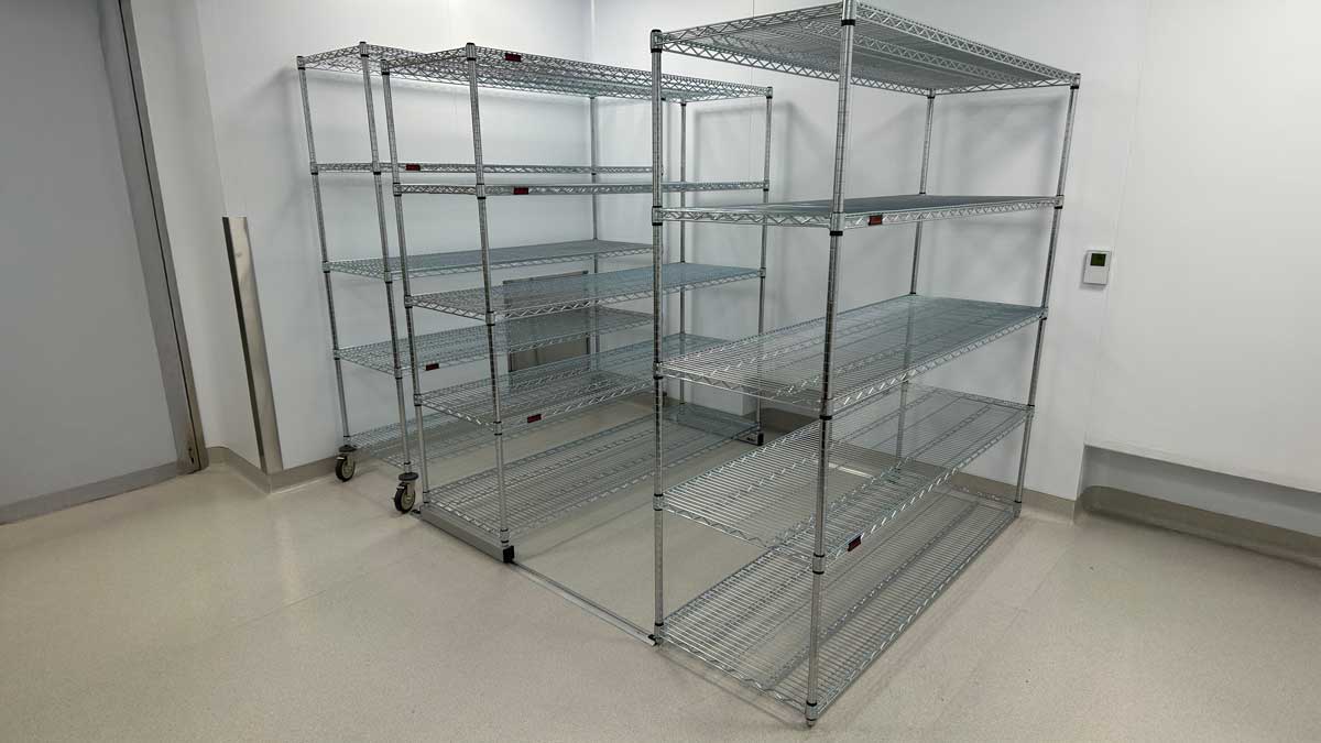 Metal wire shelving units installed in an office for organized supply and equipment storage