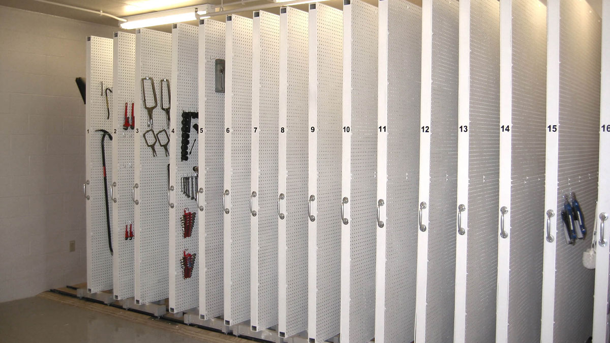 pull out mobile tool storage with numbered sliding panels holding organized tools on pegboards