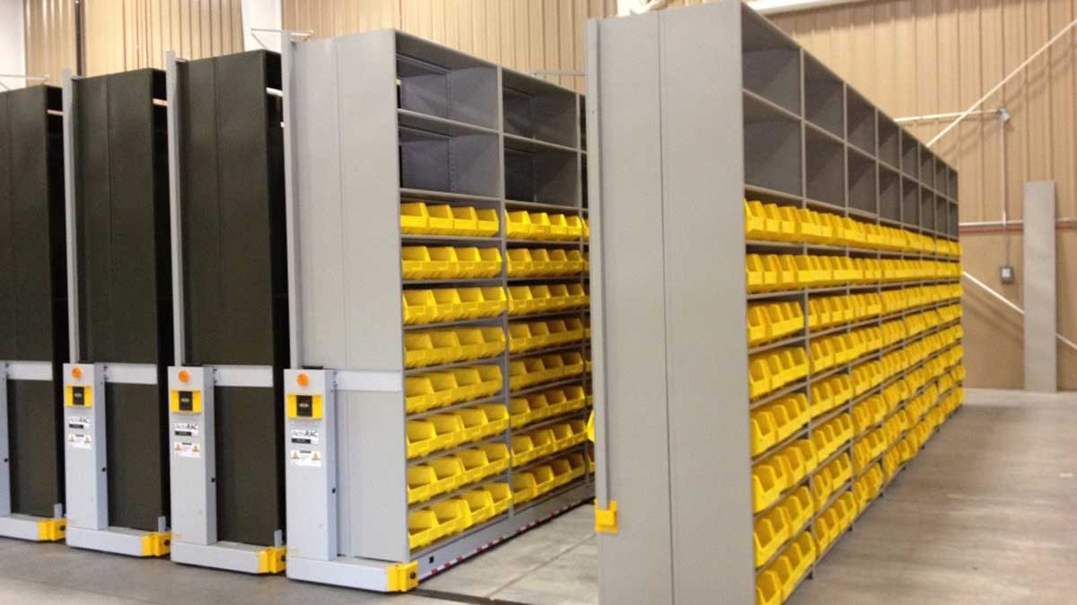 High density sliding bin shelving on mobile carriages