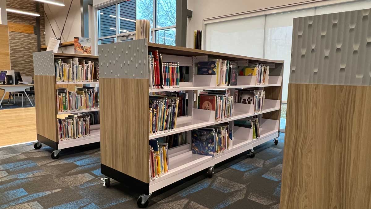 Mobile library shelving units on casters organizing books in a modern reading space.