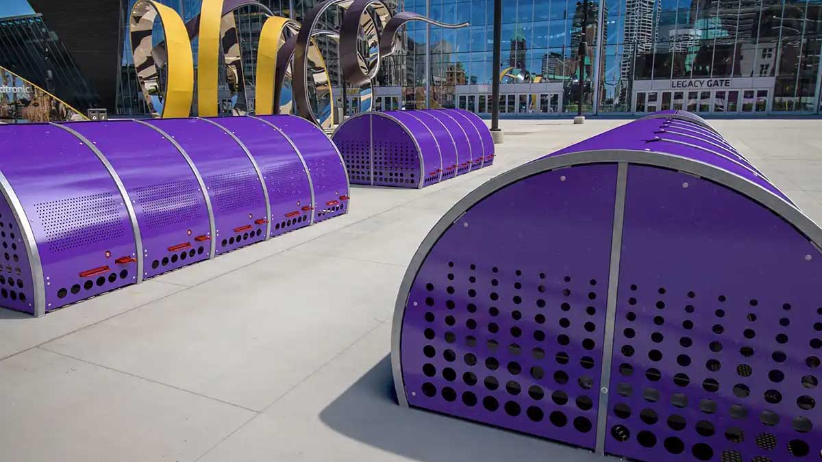 Multiple dome-style bike storage units installed outdoors in a public plaza for secure parking.