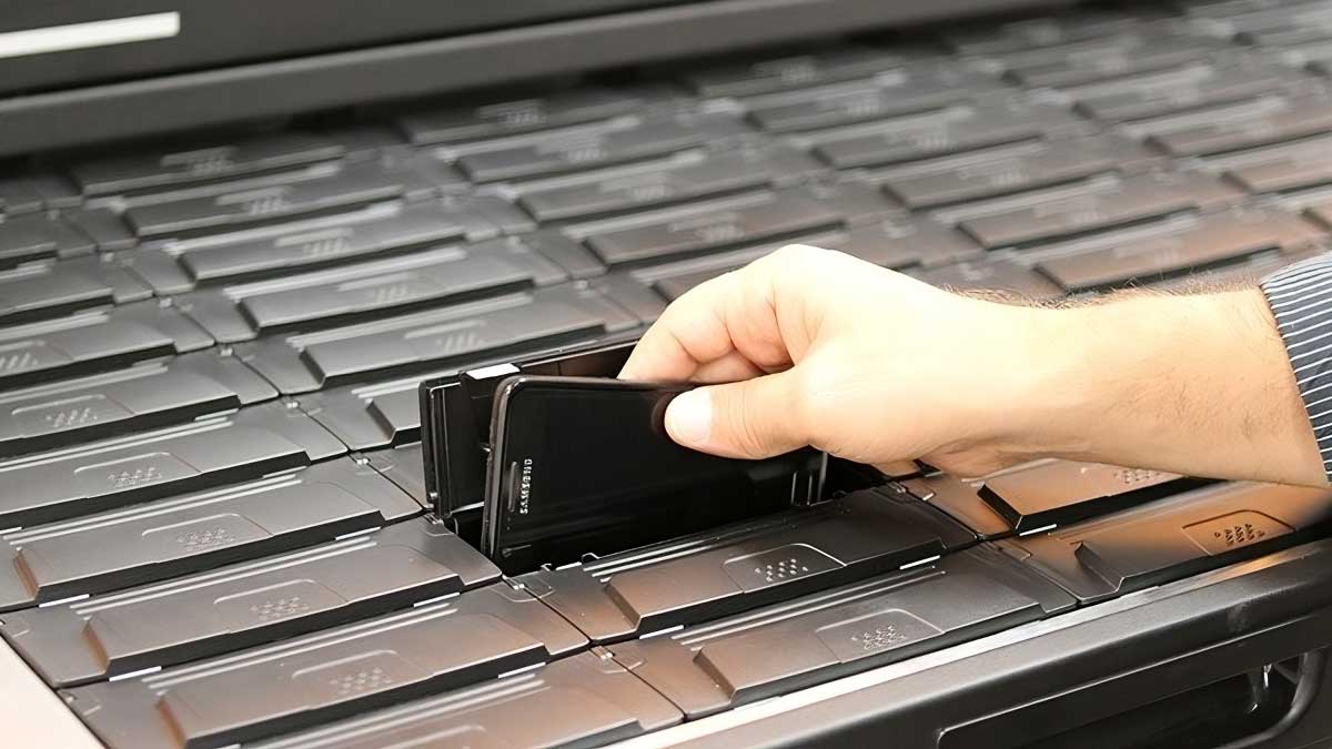 hand placing mobile devices into secure drawer for organized storage