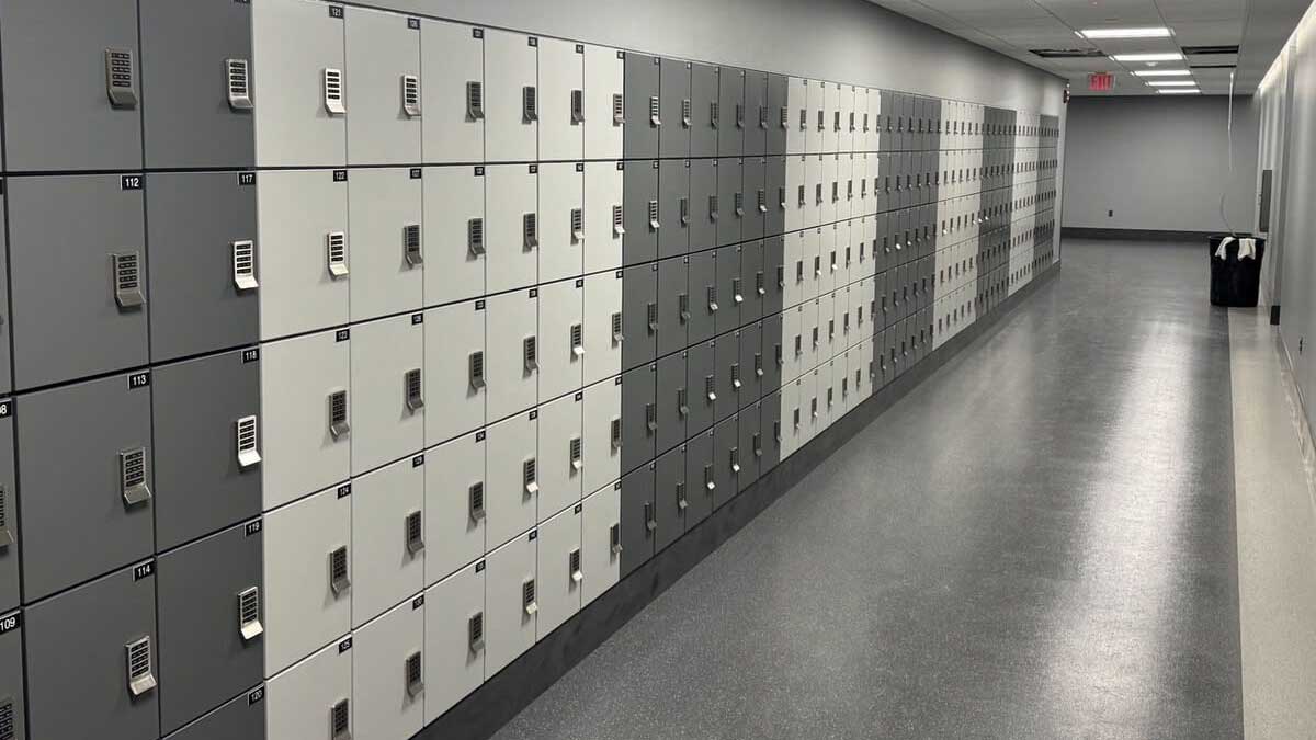 Long hallway of two-tone gray and white employee lockers with keyless combination locks and clean, modern design.