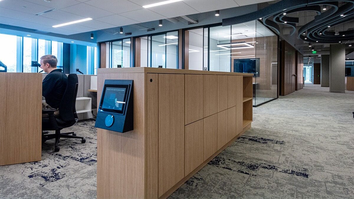 Modern wood employee lockers with digital touch screen in open office workspace