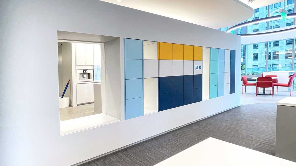 Contemporary multi-color office wall lockers with curved architecture and open lounge area