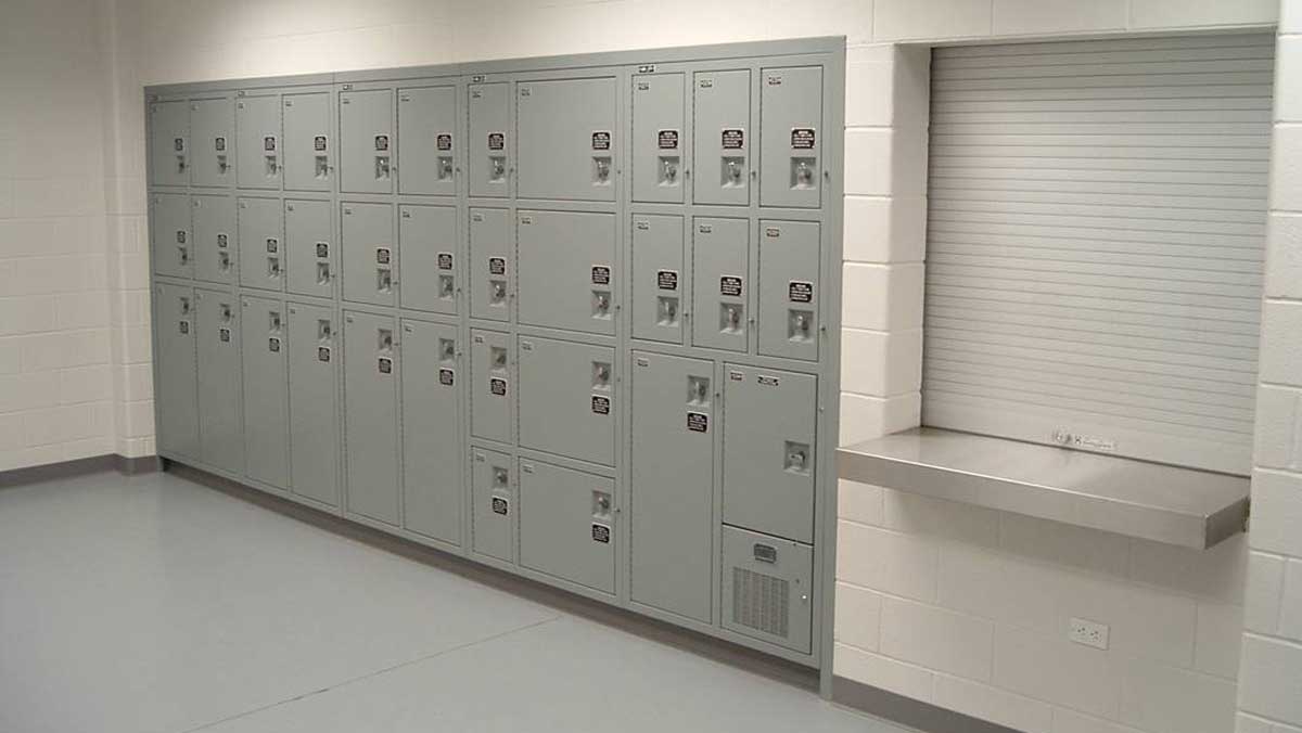 Wall-mounted green evidence lockers with keyless combination locks in secured facility