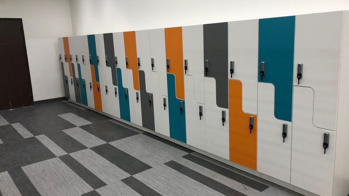 Multicolored Z-shaped lockers with keypad access designed for modern workplaces and employee storage.