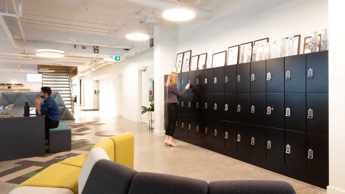 Black modern employee office lockers with digital locks in a tech company common area