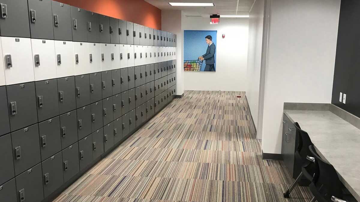 Modern temporary office lockers with keypad access in a corporate workspace corridor